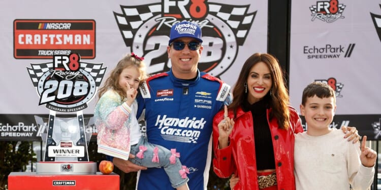 Kyle Busch celebrates with daughter, Lennix Busch, son, Brexton Busch, and wife, Samantha Busch in victory lane after winning the NASCAR Craftsman Truck Series Fr8 Racing 208 at Echo Park Speedway on Feb. 21, 2026, in Hampton, Georgia.