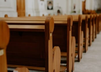 Rows of empty pews inside a church.
