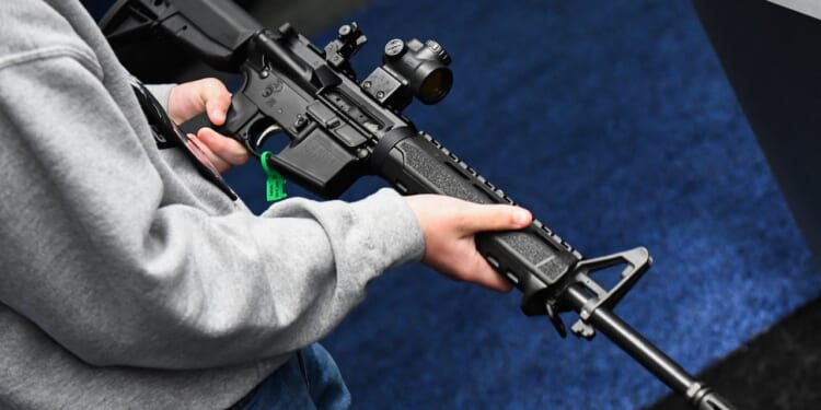 An attendee holds a Springfield Armory SAINT AR-15 style rifle.