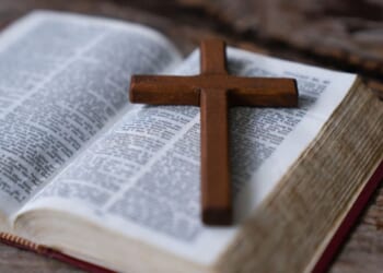 Crucifix sits at an angle on an opened Bible.