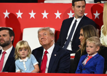 Donald Trump with granddaughter in his lap, grandson at his side, daughter and son-in-law behind him, and JD Vance to his right.