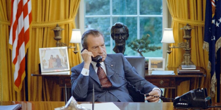 President Richard Nixon talks on the telephone at his desk in the White House's Oval Office, Washington, D.C., on June 23, 1972.
