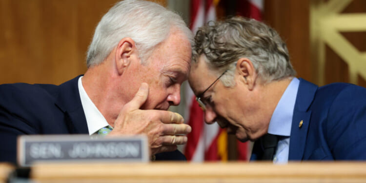 U.S. Sen. Ron Johnson (R-WI) speaks to Chairman Sen. Rand Paul (R-KY) during a business meeting with the Senate Homeland Security Committee