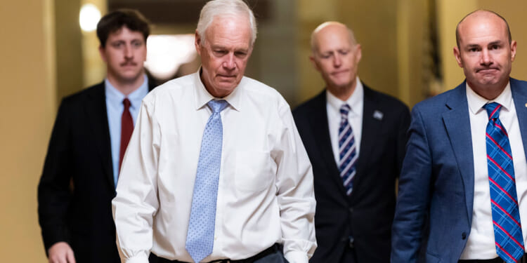 U.S. Sen. Ron Johnson (R-WI), Sen. Rick Scott (R-FL), and Sen. Mike Lee (R-UT) walk towards Senate Chambers in the U.S. Capitol.