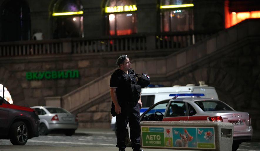 A policeman stands near the site where an improvised explosive device detonated at a restaurant in central Moscow, Saturday, Aug. 1, 2026. (AP Photo/Pavel Bednyakov)