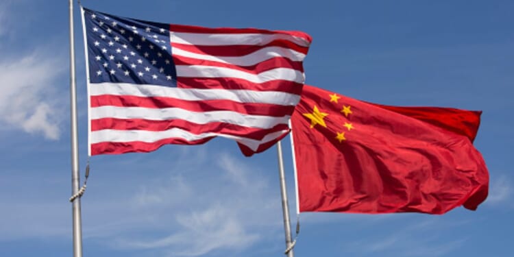 An American flag and Chinese flag wave in strong winds during the afternoon.