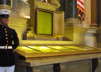 An honor guard stands next to the original copies of the Declaration of Independence, the Constitution, and the Bill of Rights on July 4, 2001 at the National Archives in Washington, D.C.