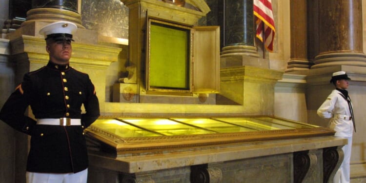 An honor guard stands next to the original copies of the Declaration of Independence, the Constitution, and the Bill of Rights on July 4, 2001 at the National Archives in Washington, D.C.