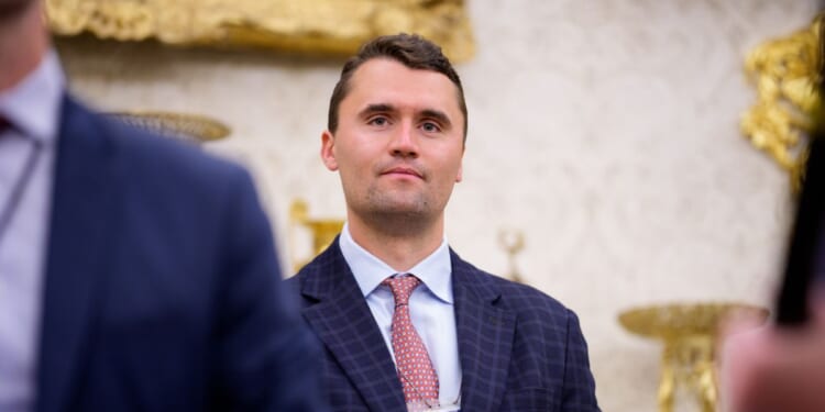 Turning Point USA co-founder Charlie Kirk stands in the back of the room as President Donald Trump speaks during a swearing in ceremony for interim U.S. Attorney for Washington, D.C. Jeanine Pirro in the Oval Office of the White House on May 28, 2025, in Washington, D.C.