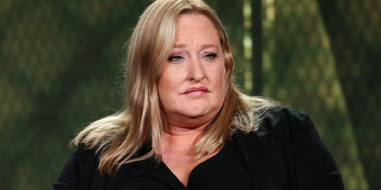 Heidi Beirich, former intelligence project director at the Southern Poverty Law Center, moved to continue her case with the SPLC. Pictured: a woman with long blonde hair, wearing a black top, sits in front of a blurred green background, looking slightly to the side with a neutral expression.