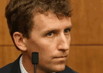 Patrick Clancy sits in front of a courtroom.