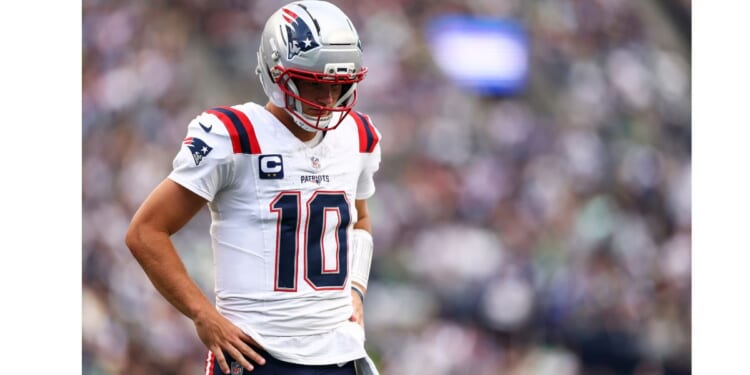 Drake Maye #10 of the New England Patriots stands on the field Wednesday during the NFL football game against the Seattle Seahawks at Lumen Field in Seattle, Washington.