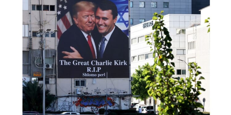 A billboard hangs on a building in Tel Aviv, Israel, showing an image of President Donald Trump embracing conservative icon Charlie Kirk, who was assassinated Sept. 10, 2025. The banner went up on the building shortly after Kirk's death.