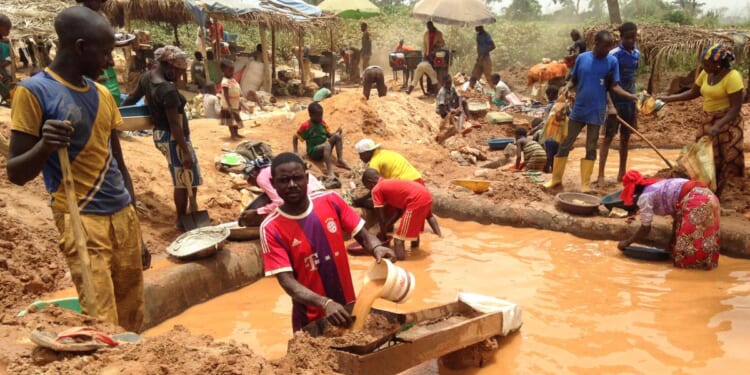 In this photograph taken on April 4, 2018, gold miners work at a mining site in the Cameroon town of Betare Oya.