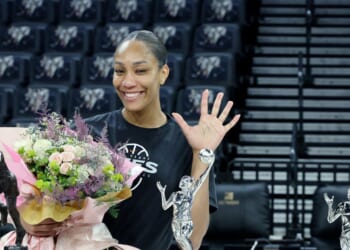 A'ja Wilson of the Las Vegas Aces poses while holding a bouquet of flowers after receiving the 2026 WNBA MVP award, her third consecutive and fifth career trophy, after a team walkthrough at Michelob ULTRA Arena on Oct. 8, 2026, in Las Vegas, Nevada.
