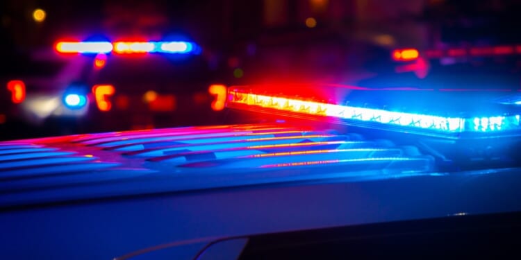 Red and blue police lights flash at a crime scene.
