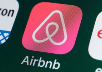 The Airbnb logo is pictured on a phone screen.
