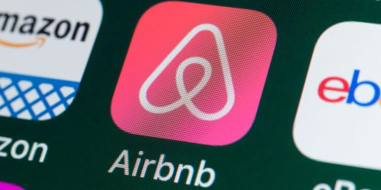 The Airbnb logo is pictured on a phone screen.