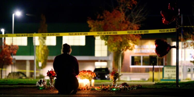 A woman grieves at a candlelight memorial out front of Silver Rail Elementary School on Oct. 15, 2026, in Bend, Oregon.