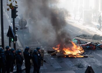 Police officers stand near a fire during an unauthorized demonstration marked by riots and clashes with law enforcement at Place de la Republique in Paris, Ile-de-France, France, on Oct. 18, 2026.