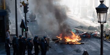 Police officers stand near a fire during an unauthorized demonstration marked by riots and clashes with law enforcement at Place de la Republique in Paris, Ile-de-France, France, on Oct. 18, 2026.
