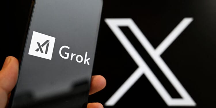 This photograph shows a smartphone bearing the logo of Grok, a generative artificial intelligence chatbot developed by xAI in front of the X logo in Brussels on Jan. 12, 2026.