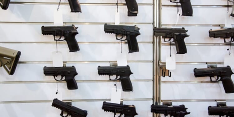 A gun rack is viewed on a wall.
