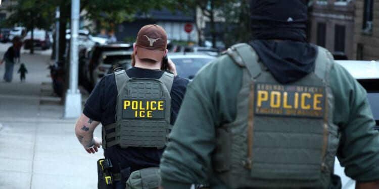 Federal agents walk near the scene where a man was shot by an Immigration and Customs Enforcement officer during an operation in the Bronx borough of New York on Oct. 8, 2026, according to local media and police.