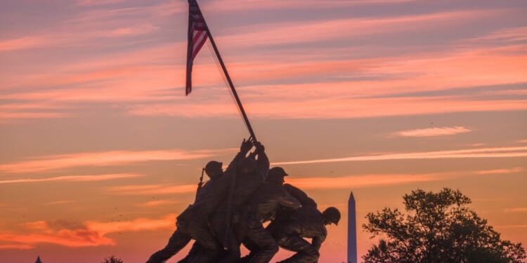 Sunrise turns the sky orange and red behind the U.S. Marine Corps War Memorial on Oct. 2, 2026, in Arlington, Virginia.