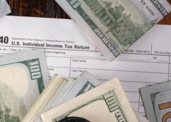 Money is pictured lying on a 1040 form.