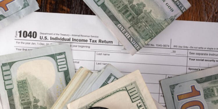 Money is pictured lying on a 1040 form.