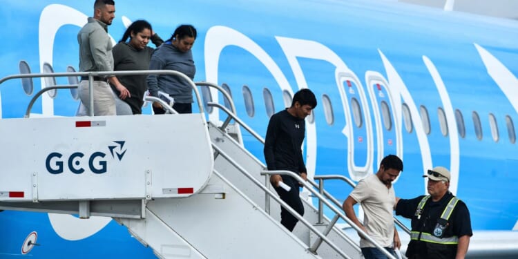 Migrants deported from the United States get off an airliner at the runway of the Juan Santamaria International Airport in Alajuela, Costa Rica, on April 11.