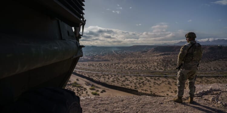 A U.S. Army soldier stands next to a Stryker armored infantry transport vehicle, which has been deployed along the Mexican border as part of the military's Joint Task Force Southern Border mission, in Sunland Park, New Mexico, on April 4, 2025.