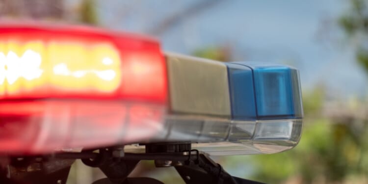 Emergency lights flash on top of a police car.