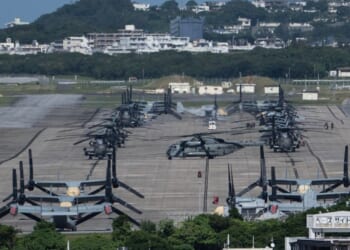 Helicopters and V-22 Ospreys are seen parked on the tarmac near buildings at Marine Corps Air Station Futenma in Ginowan, Okinawa prefecture, on Oct. 9, 2026.