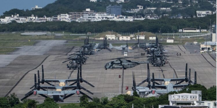 Helicopters and V-22 Ospreys are seen parked on the tarmac near buildings at Marine Corps Air Station Futenma in Ginowan, Okinawa prefecture, on Oct. 9, 2026.