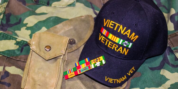 A Vietnam veteran’s hat is pictured on a camouflage fabric.
