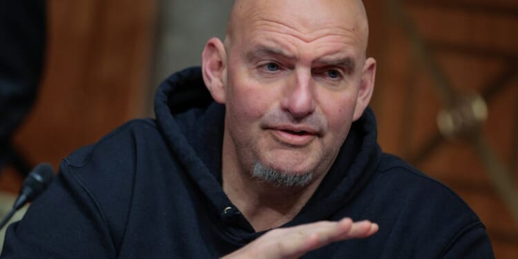 Sen. John Fetterman prepares to vote to advance Sen. Markwayne Mullin to be Secretary of the Department of Homeland Security during a markup hearing in the Dirksen Senate Office Building on Capitol Hill on March 19, 2026, in Washington, D.C.